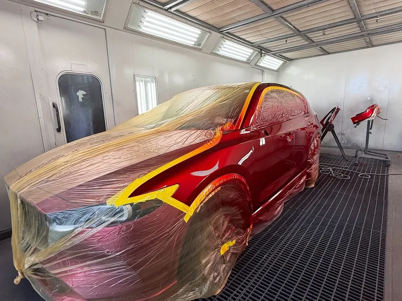 Red sedan masked and ready for paint booth