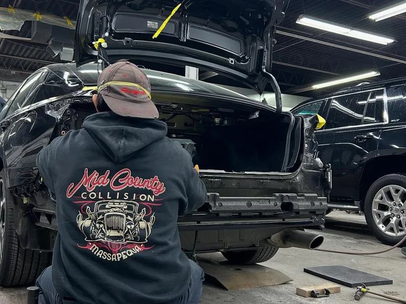 Mid-County technician repairing rear collision damage
